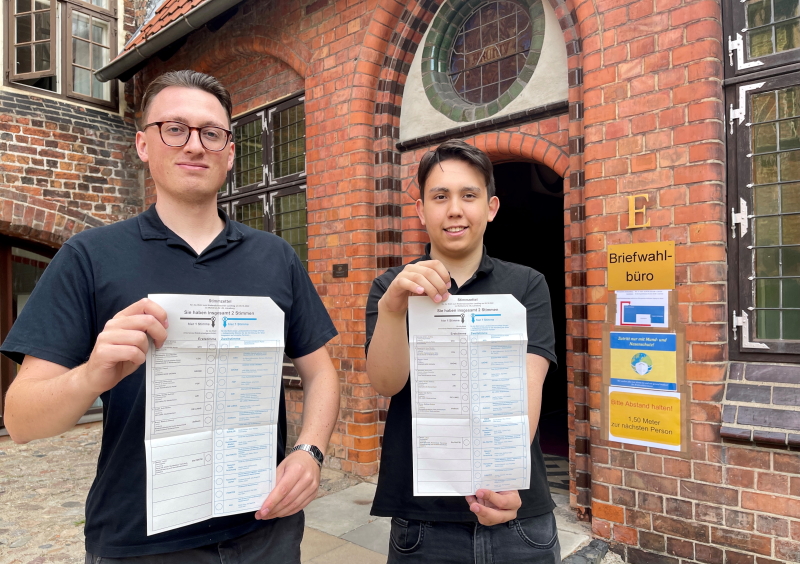 Ben Gschwentner (links) und Justin Lipka vom Briefwahl-Team der Stadt zeigen die Stimmzettel für die Landtagswahl. Foto: Hansestadt Lüneburg.