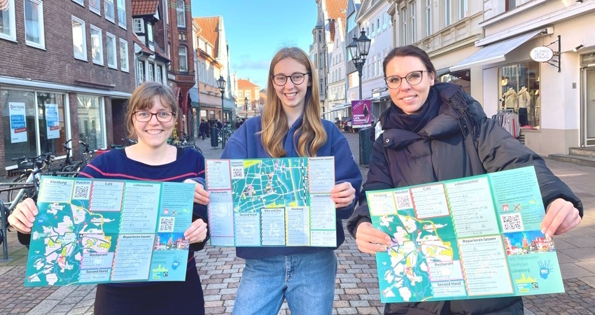 Foto: Hansestadt Lüneburg. Von links: Eva Kern, Mavie Zcernikow von JANUN Lüneburg und Pia Wiebe, Bereichsleiterin für Klimaschutz und Nachhaltigkeit bei der Stadt Lüneburg, präsentieren im Februar 2023 den ersten „WELTbewussten Stadtplan“.