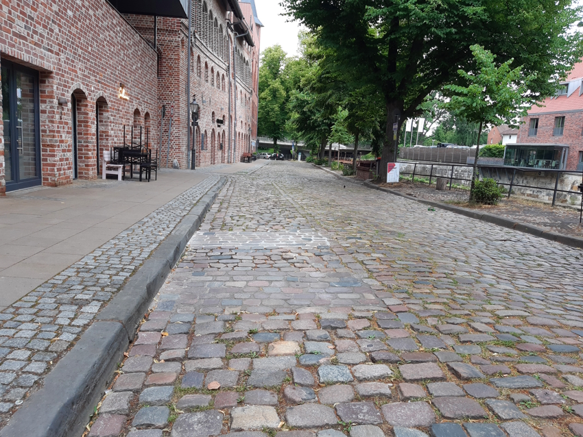 Foto: FUSS e.V. Lüneburg. So sah die Salzstraße am Wasser aus. Jetzt sollen beidseitig gut zu befahrene, abgeschliffene Steine gelegt werden - und die zu Fuß Gehenden endlich ungestört spazieren.