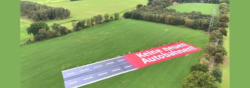 Foto: Malte Hübner. Banner am Ort der geplanten A39 in Lüneburg Hagen (01.10.2023).Tatsächlich wird der Bau noch erheblich breiter sein, denn es kommt beidseitig noch die Standspur bzw. der Einfädelstreifen dazu sowie Auf- und Abfahrten. 