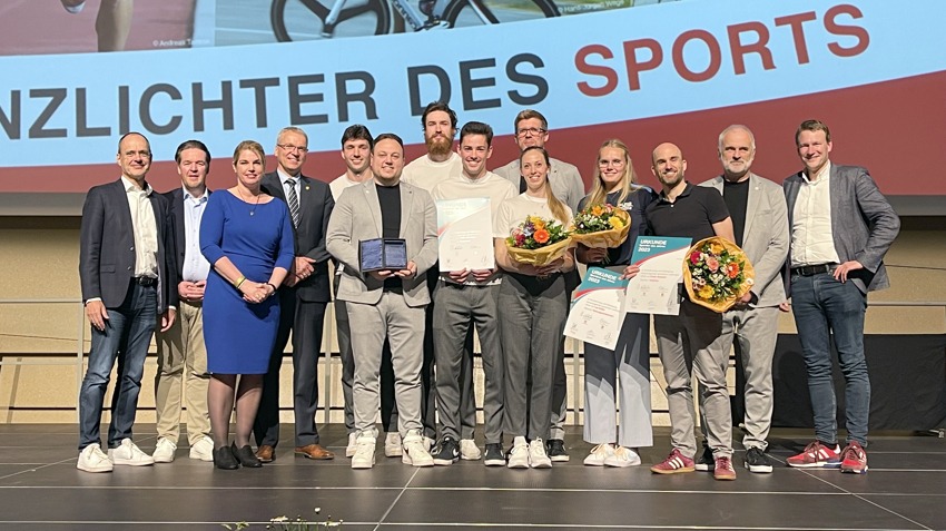 Foto: Hansestadt Lüneburg, 27.04.2024. Rettungssportlerin Lea Kötter (4. von rechts), Cross-Triathlet Frank Reimann (3. von rechts) sowie eine Delegation der SVG-Volleyballer (Mitte) freuen sich über ihre Auszeichnungen.