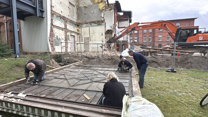 Mitwirkende im ALA lösen die Befestigungen des Glasfensters. Foto: H. Boldt.