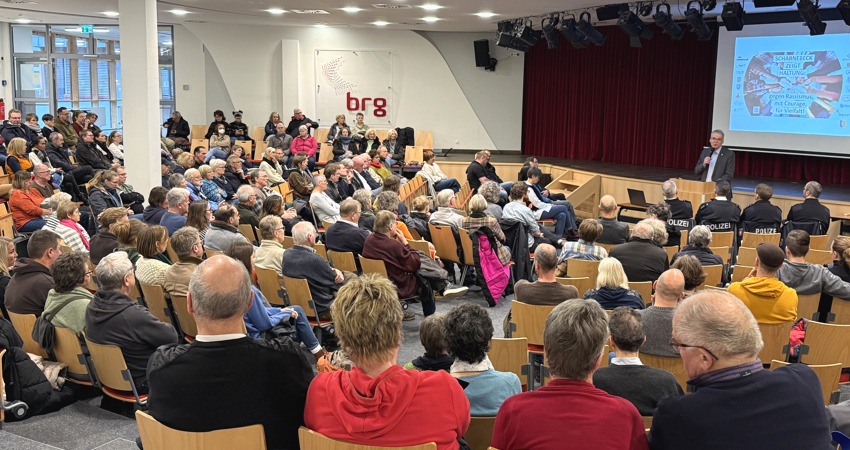 Foto: Landkreis Lüneburg. Lüneburgs Landrat Jens Böther (rechts am Pult) informierte die Bürgerinnen und Bürger in Scharnebeck am 18.01.2025 über die Erstaufnahmeeinrichtung.