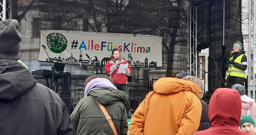 Foto: Lüne-Blog. Rednerin beim Klimastreik von Fridays for Future Lüneburg auf dem Marktplatz, 14.02.2025. 