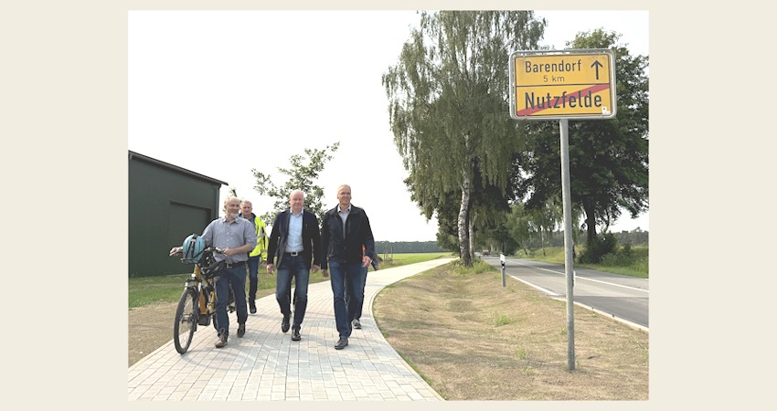 Foto: Landkreis Lüneburg. Schritten gemeinsam den neuen Radweg entlang der K28 ab (v.r.n.l.): Landrat Jens Böther, Laars Gerstenborn (Samtgemeindebürgermeister der Samtgemeinde Scharnebeck), Raino Fraedrich (Betrieb Straßenbau und -unterhaltung) und Tobias Winkelmann (Fachdienst Mobilität beim Landkreis Lüneburg). Foto: Andreas Tamme.