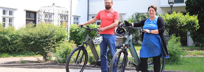 Foto: Landkreis Lüneburg. Sie treten in die Pedale: Henrick Müller und Christine Meyer radeln ab sofort klimaneutral zu ihrem Arbeitsplatz beim Landkreis.