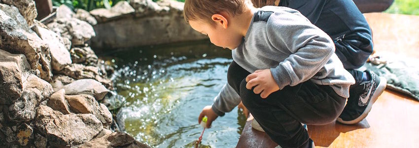 Zwei kleine Kinder spielen vor einem Wasserbecken. Foto: Avacon Wasser: Begleitfoto zur Veranstaltungsreihe in Lüneburg im Juni 2025.