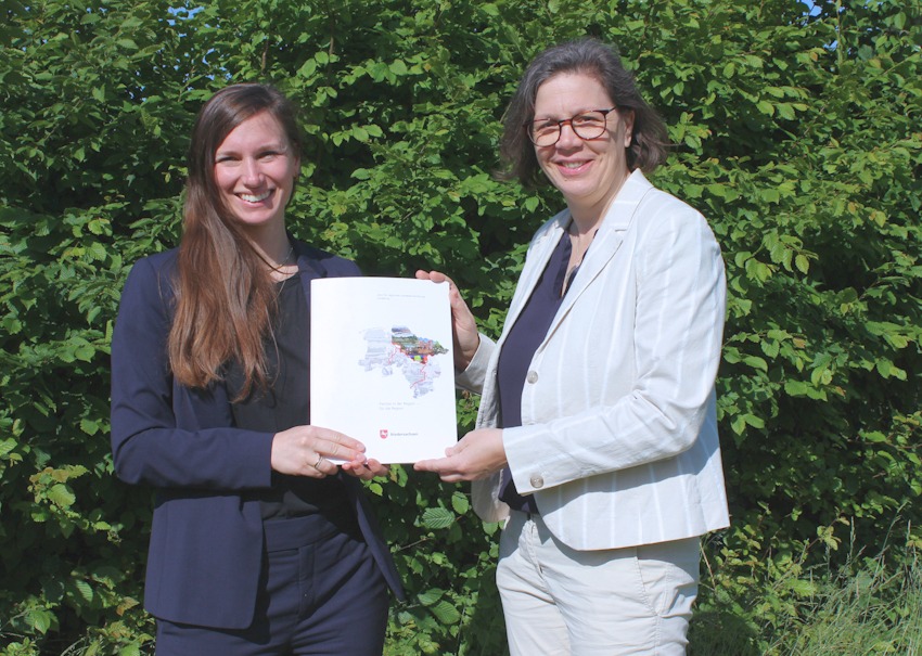 Foto: Landkreis Lüneburg. Janna Hoveida (Landkreis Lüneburg), links,  erhält am 13. Juni 2025 den Förderbescheid von Dr. Birgit Nolte (ArL, Lüneburg) für das Projekt „Integriertes wassertouristisches Konzept für den Fluss Ilmenau“.