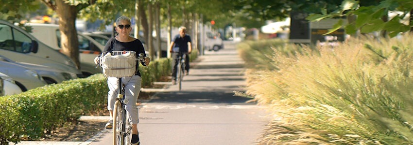 Ältere Frau auf dem Fahrrad auf einem Radweg. Foto: Icsilviu, Pixabay.
