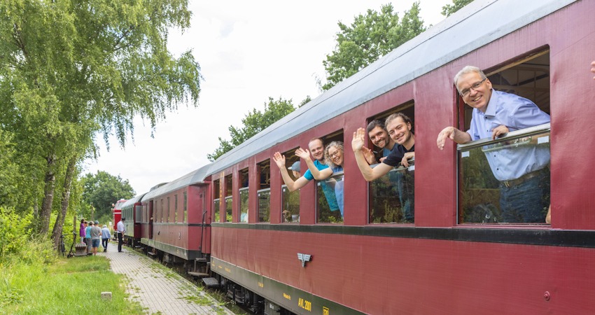 Foto: Malte Hübner. Mit dem Zug von Lüneburg nach Bleckede: Beim Halt in Ebensberg grüßen von links: Jonas Korn (VCD), Dr. Julia Verlinden (Bündnis 90/Die Grünen), Mitglieder von VCD bzw. Fridays for Future und Landrat Jens Böther (Landkreis Lüneburg).