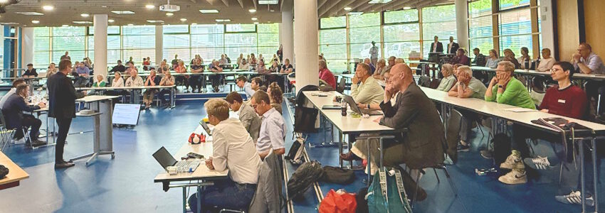 Foto: Hansestadt Lüneburg. Blick in die Aula der Berufsschule BBSI bei der Info-Veranstaltung von DB, Landkreis und Hansestadt zu den kommenden Baumaßnahmen im Stadtosten.