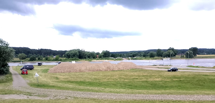 Foto: BI. Berge von ausgebaggertem Sand neben dem Fähranleger.
