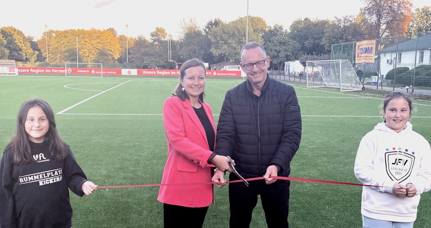 Foto: Hansestadt Lüneburg. Bürgermeisterin Jule Grunau und Lüneburgs Sportdezernent Matthias Rink durchschnitten das rote Band und eröffneten damit den neuen Kunstrasenplatz, den die Hansestadt mit 500.000 Euro unterstützt hat.