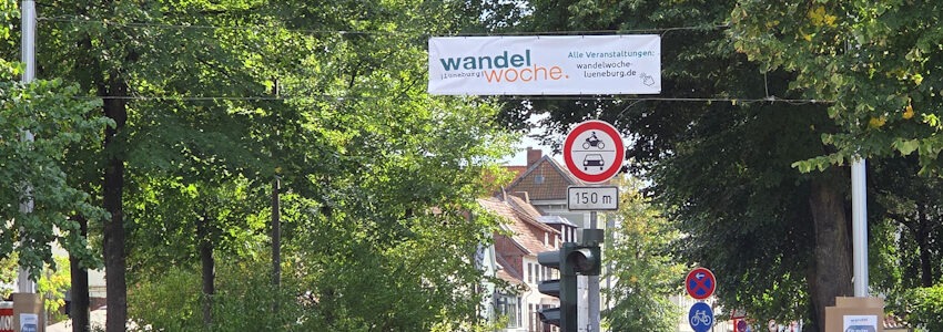 Foto: Lüne-Blog. Wandelwoche: Ein Transparent in der Bardowicker Straße weist auf die kommende Wandelwoche 2025 hin.