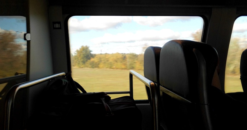 Foto: Sibylle Wickbold_Unterwegs im Zug - vor dem Fenster Nebel über der grünen Landschaft.