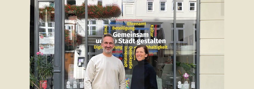 Foto: Hansestadt Lüneburg. Vor dem Dialograum Innenstadt: Carmen Sillmann aus dem Bereich Kultur und Mathias Schneider vom Team „Strategische Innenstadtentwicklung“ der Hansestadt Lüneburg freuen sich auf viele Interessierte zum Themenmonat „Innenstadt und Kultur“.