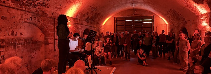 Foto: Hansestadt Lüneburg, August 2025. Musikveranstaltung im alten Tunnel - getaucht in rotes Licht.