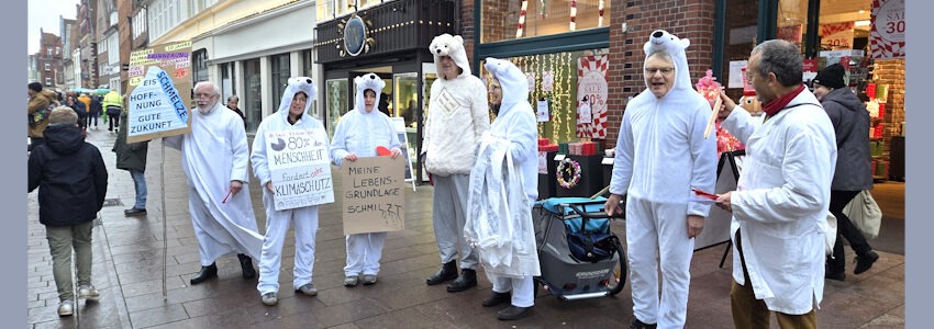 Foto: Lüne-Blog. Demonstration in Lüneburg am 13. Dezember 2025. Zum 10. Jahrestag des Pariser Klimaabkommens ziehen als Eisbären verkleidete Mitglieder des Widerstandskollektivs Lüneburg durch die Fußgängerzone.