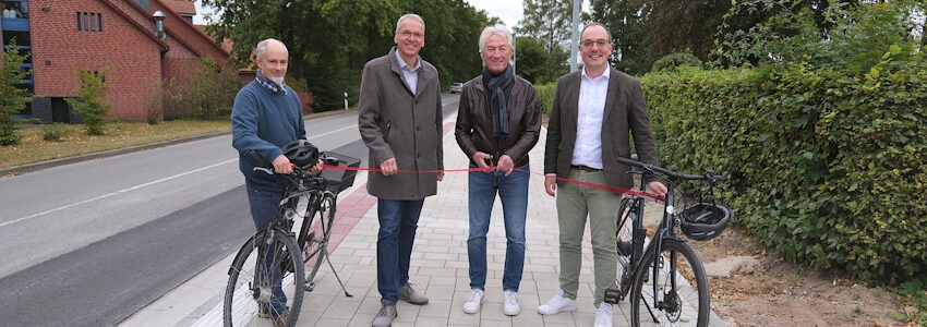 Foto: Samtgemeinde Gellersen. Tobias Winkelmann (Fachdienst Mobilität Landkreis Lüneburg), Landrat Jens Böther, Christian Purps (Bürgermeister von Reppenstedt) und Samtgemeinde-Bürgermeister Steffen Gärtner auf dem neuen Geh- und Radweg entlang der L216 in Reppenstedt.