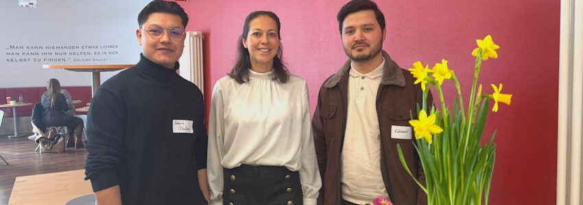 Foto: Landkreis Harburg. Bei der Veranstaltung am 14. Februar 2026 in Winsen: Kreisrätin Ana Cristina Bröcking (Mitte) spricht zusammen mit Zakaria (links) und Nadeem (rechts) über Herausforderungen und Erfolge.
