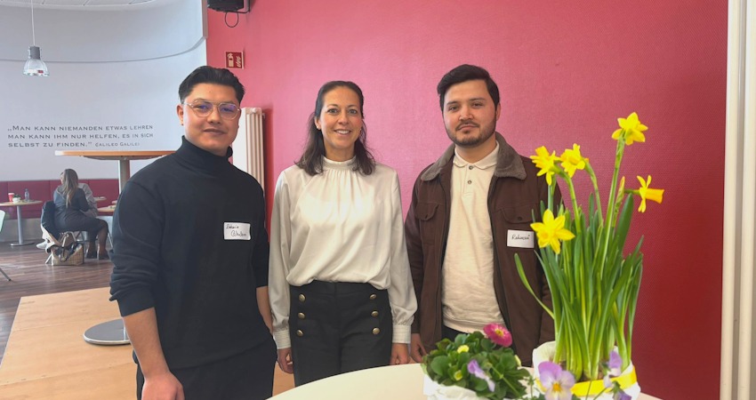 Foto: Landkreis Harburg. Bei der Veranstaltung am 14. Februar 2026 in Winsen: Kreisrätin Ana Cristina Bröcking (Mitte) spricht zusammen mit Zakaria (links) und Nadeem (rechts) über Herausforderungen und Erfolge.