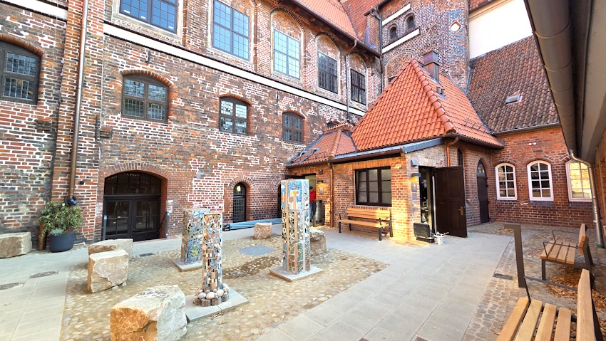 Foto: Lüne-Blog. Eröffnung der neuen Toiletten am Rathaus, rechts das Behinderten-WC. Im September 2025 war der Innenhof geschmückt mit Skulpturen der Ikarus-Kunstschule als Leihgabe.