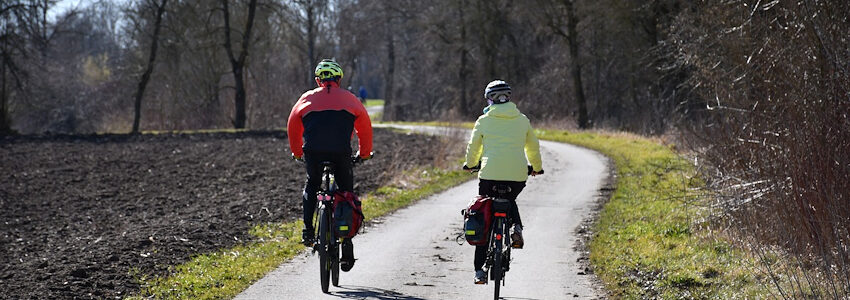 Foto: Damian_Konietzny, Pixabay. Zwei Menschen unterwegs auf Radtour durch die Frühlingslandschaft.
