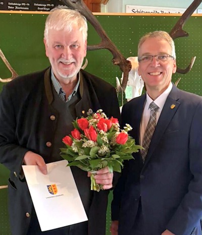 Hans-Christoph Cohrs mit seiner Auszeichnung, rechts Landrat Jens Böther.