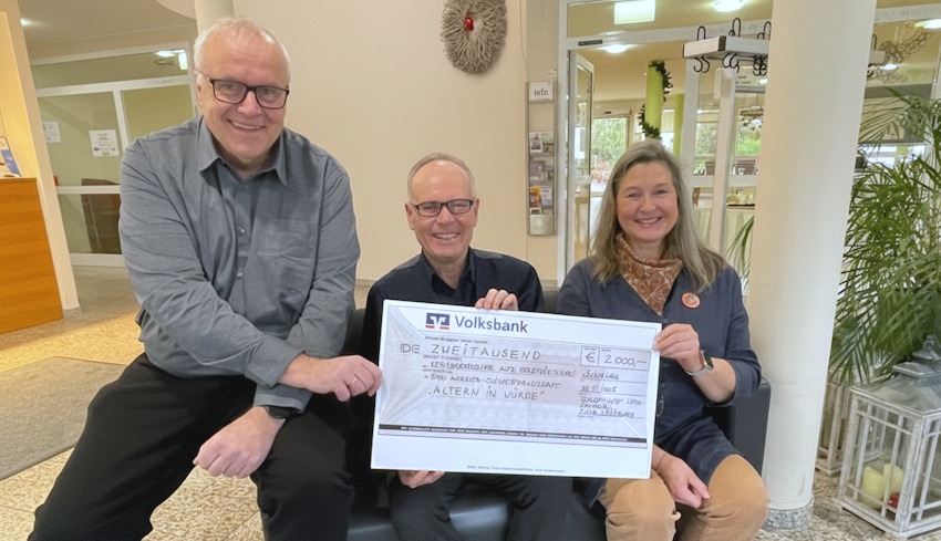 Foto: Soroptimist International Club Lüneburg. 2000 Euro ermöglichen bedürftigen Bewohnerinnen im Seniorenheim „Alte Stadtgärtnerei“ Friseur- oder Fußpflegebesuche. Im November 2025 übergaben Clubpräsidentin Birgit Meyer-Thaut und der britische Schauspieler Mark Lyndon einen entsprechenden Scheck  an Heimleiter Thomas König. 