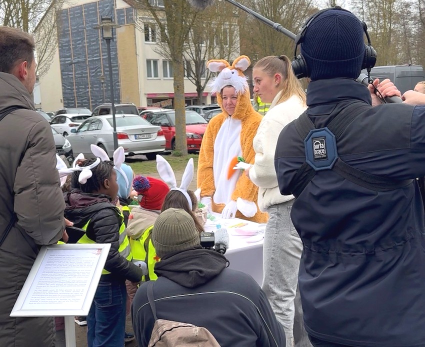 Foto: Stadtmarketing Uelzen. Osteraktion 2026: Während hier schon die nächsten anstehen für ihre Teilnahmekarte, wird der Osterhase interviewt.