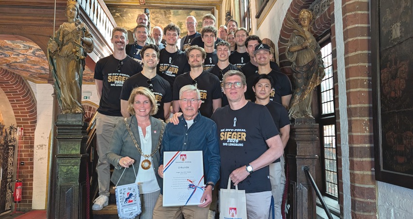 Foto: Hansestadt Lüneburg. Strahlende Mannschaft: Lüneburgs Oberbürgermeisterin Claudia Kalisch und die DVV-Pokalsieger der SVG Lüneburg nach dem Saisonende am 8. Mai 2026 im Rathaus der Hansestadt. 