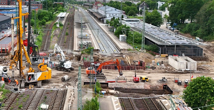 Foto: DB InfraGO AG, 3. Drohnenaufnahme: Blick auf den Bahnhof und die Brückenbaustelle in Lüneburg im Juni 2026.