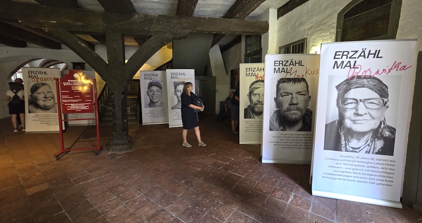 Foto: Lüne-Blog. Die Ausstellung „Obdach“ in der Eingangshalle des Klosters, noch bis zum 21. August 2026 zu sehen. In der Eingangshalle ist auch der beeindruckende Laufbrunnen zu finden.